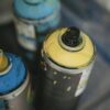 Artistic close-up of colorful spray paint cans used for graffiti.